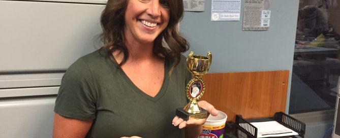 A female employreee receiving an award at the office