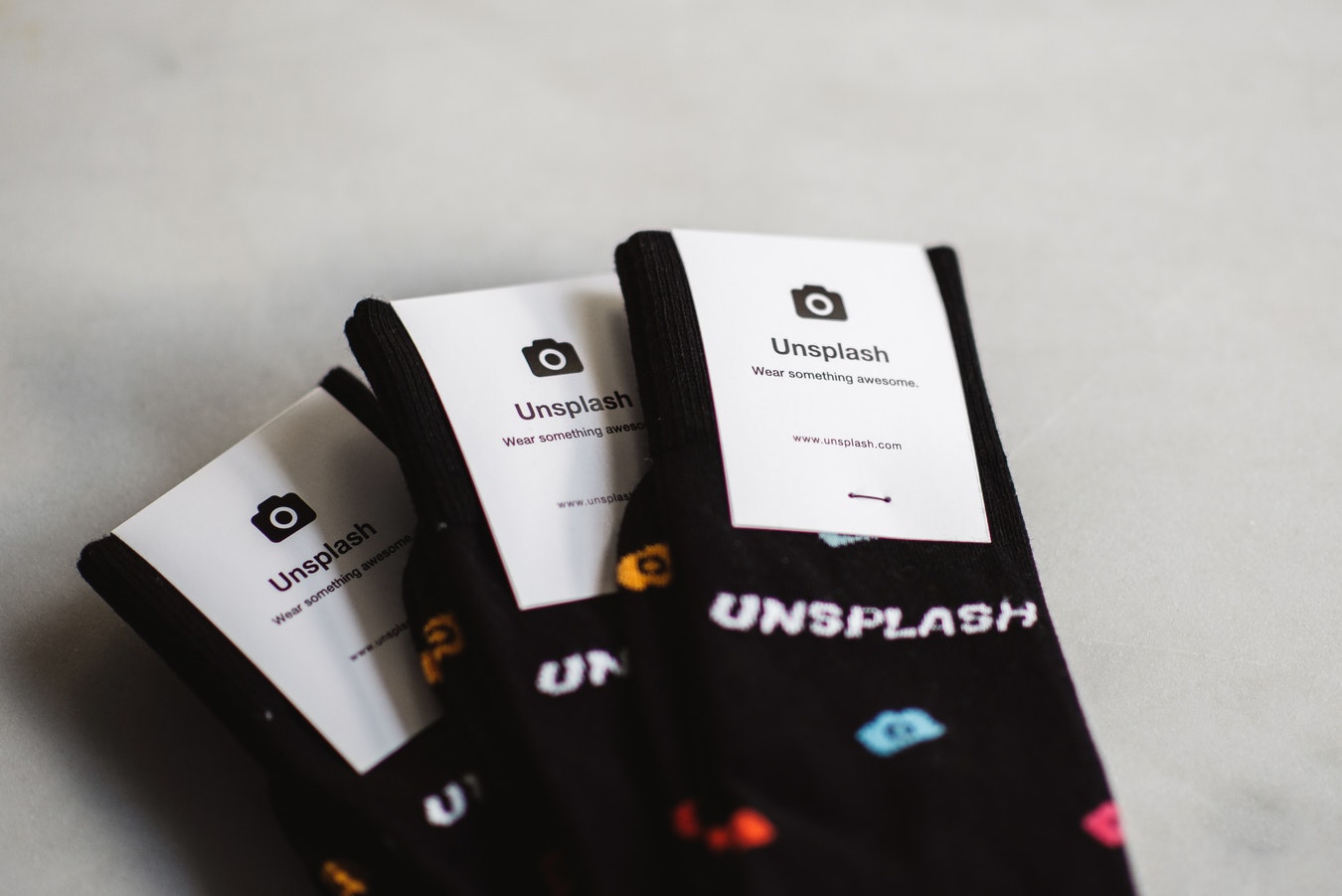3 pairs of black socks with the Unsplash label